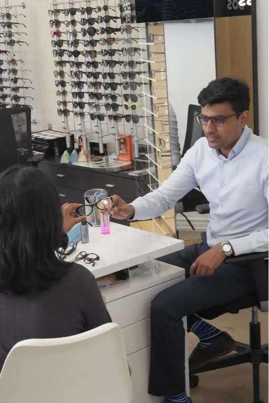 An optician helping a customer choose frames at Haven View Optics